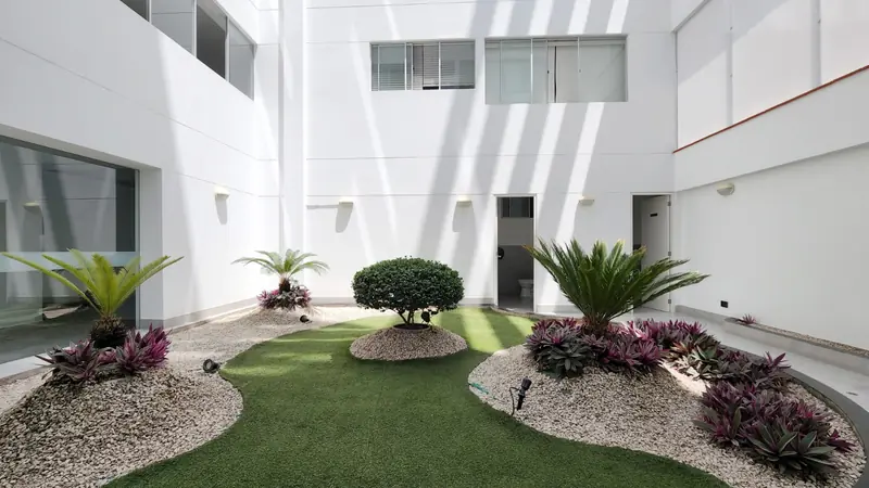 Patio interior de un edificio residencial con jardín