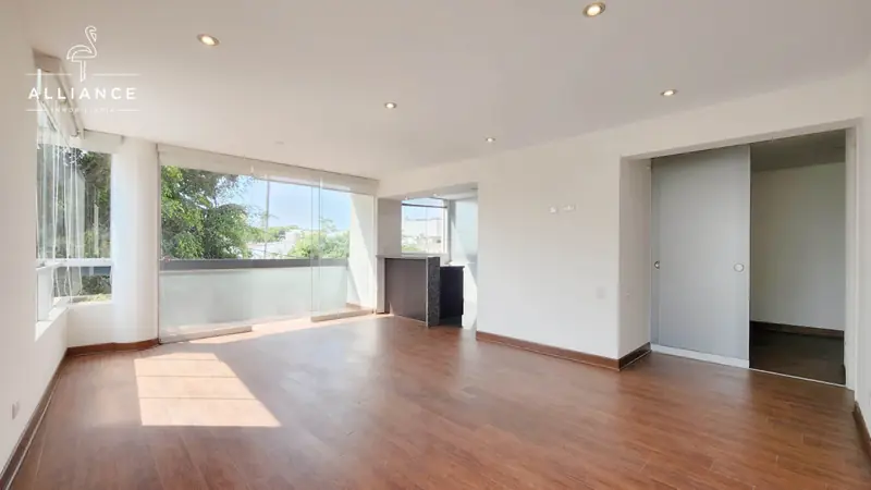 Ambiente amplio con ventanal y piso laminado