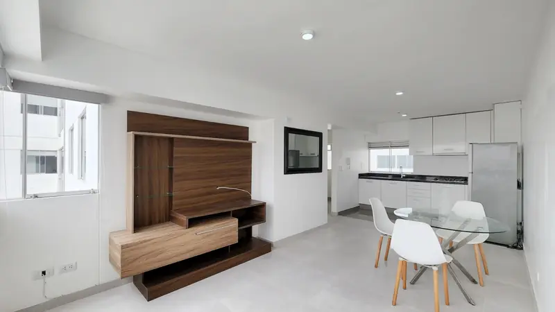 Cocina abierta y comedor con mueble de televisión en madera